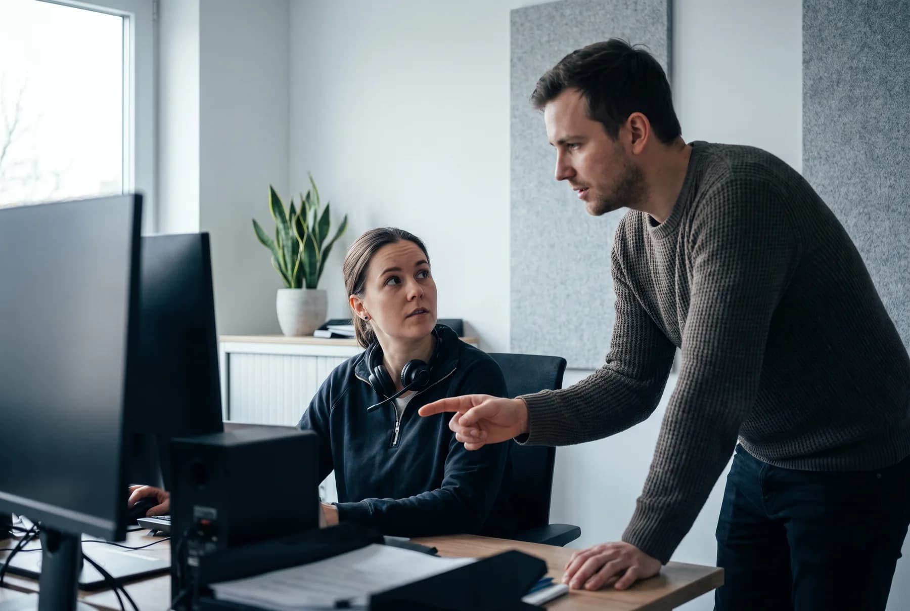 Zwei Service-Desk-Mitarbeitende besprechen einen Vorgang am Arbeitsplatz.